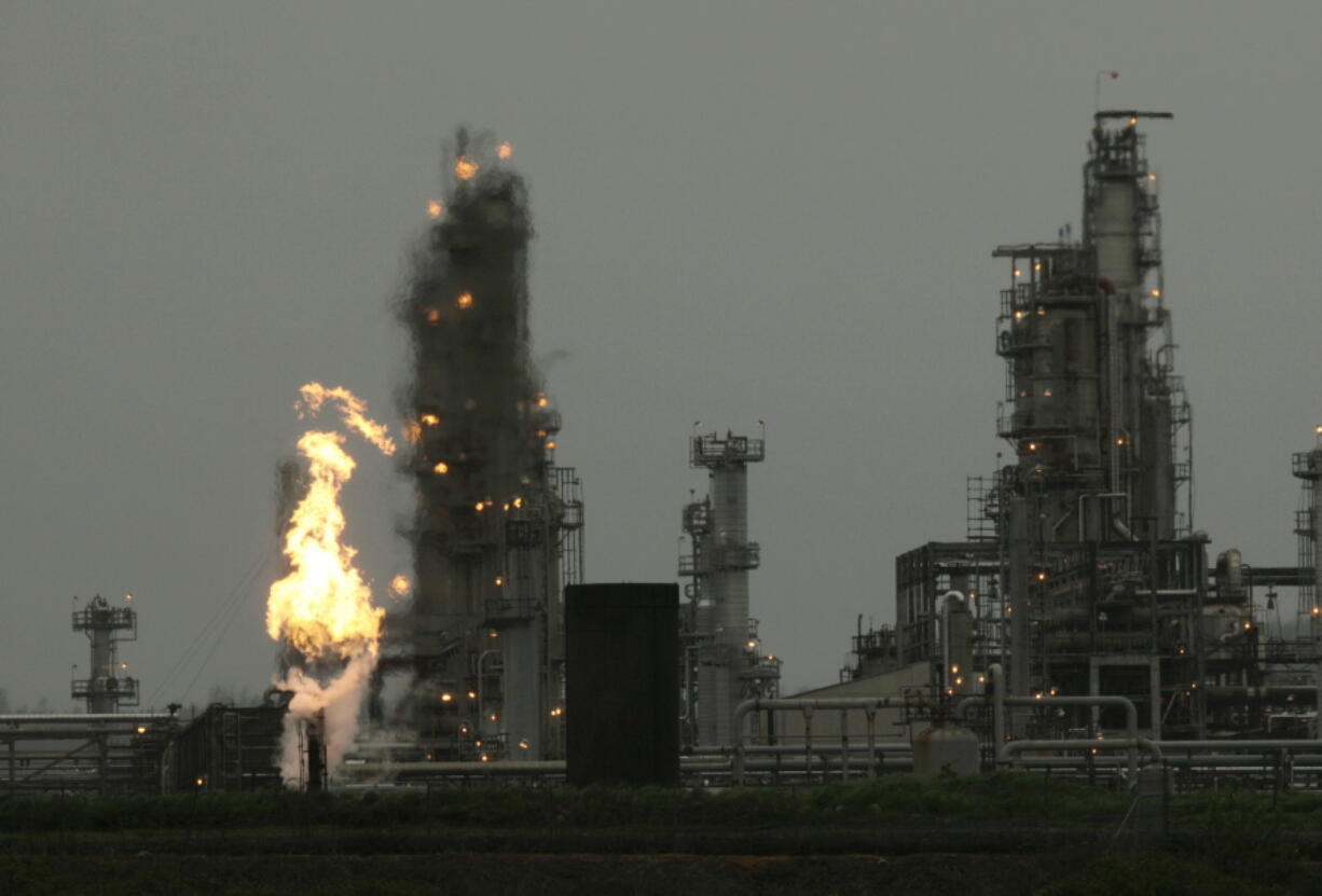 FILE - In this April 2, 2010, file photo, a  Tesoro Corp. refinery, including a gas flare flame that is part of normal plant operations, is shown in Anacortes, Wash. after a fatal overnight fire and explosion. (AP Photo/Ted S.