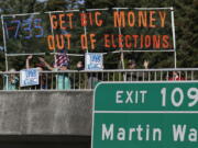 Supporters of Initiative 735 hold a banner Sept. 22 above Interstate 5 during the evening commute in Lacey. Proponents of the statewide ballot initiative want to get big money out of politics by backing a federal constitutional amendment that says free speech in the form of political contributions belongs to people, not corporations. Opponents of the measure say the government shouldn&#039;t limit the First Amendment. (AP Photo/Ted S.