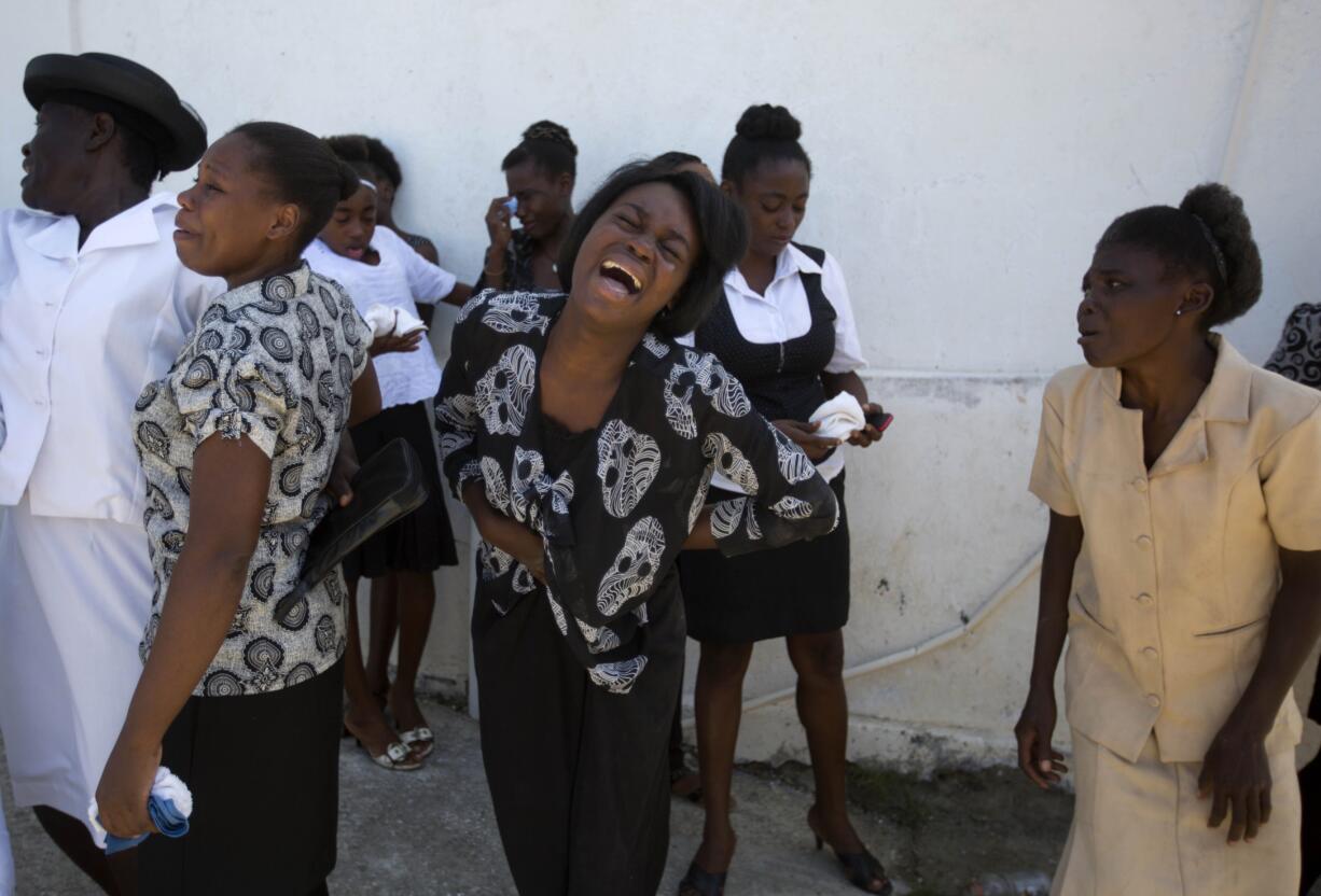 Women from the Laguerre family cry during the burial of Roberto Laguerre in Jeremie, Haiti, Saturday, Oct. 8, 2016. Roberto, 32, died when the wall of a church next door to his home fell during Hurricane Matthew.