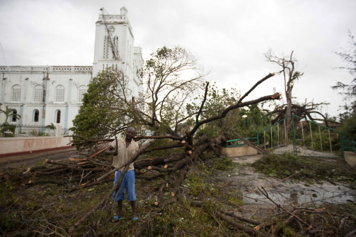 A man cuts a tree felled by Hurricane Matthew, outside the cathedral in Les Cayes, Haiti, on Thursday. Two days after the storm rampaged across the country&#039;s remote southwestern peninsula, authorities and aid workers still lack a clear picture of what they fear is the country&#039;s biggest disaster in years.