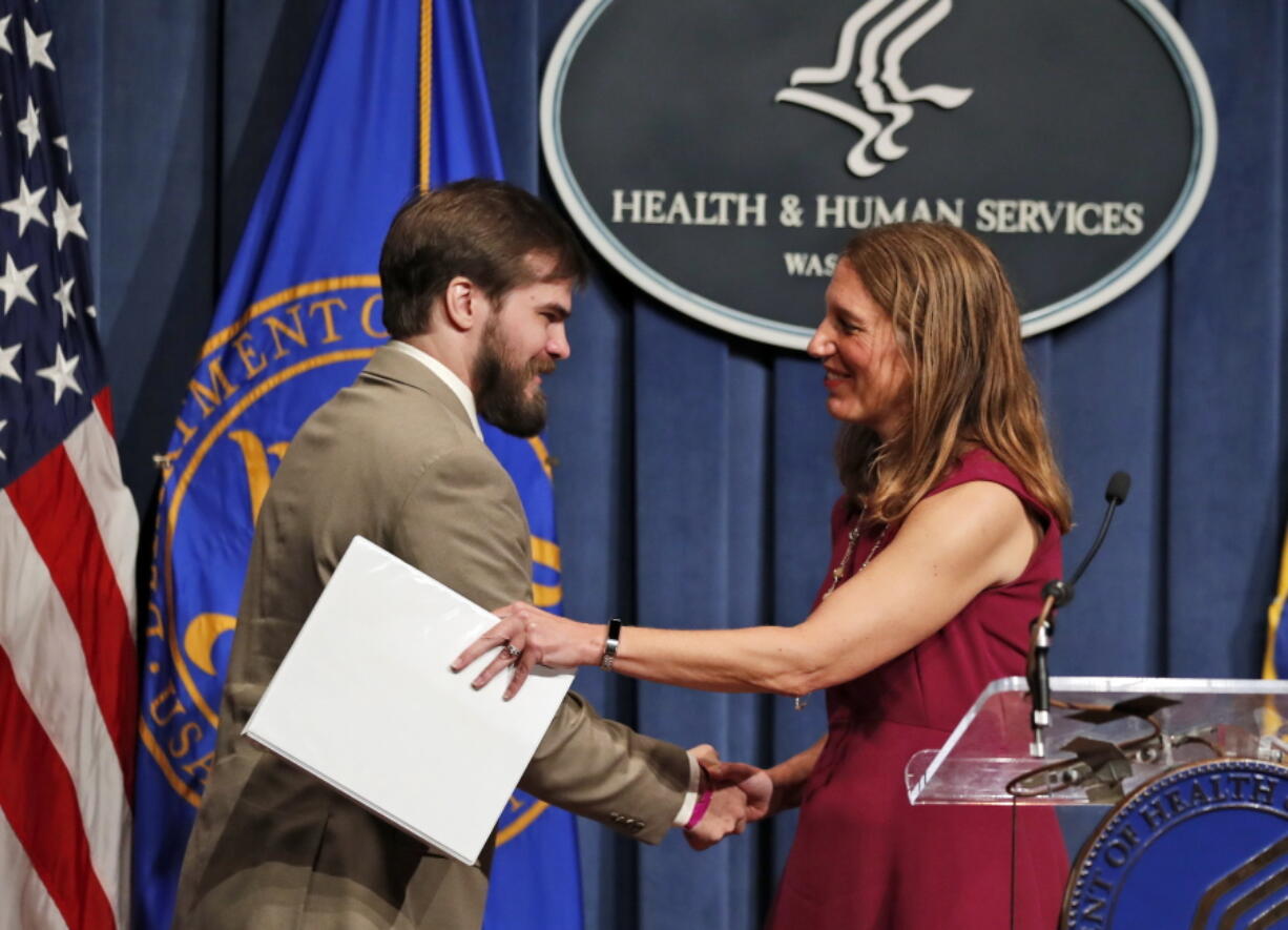 Nathan Auldridge of Salem, Va., left, is greeted by Health and Human Service (HHS) Secretary Sylvia Burwell after he introduced at a news conference about goals for the Obama administration&#039;s final health care open enrollment Wednesday at the HHS in Washington.