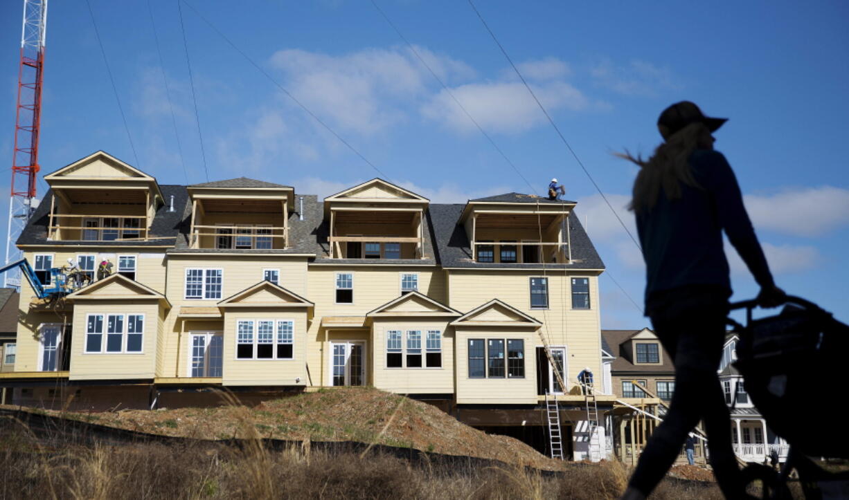 A pedestrian passes townhouses under construction in February in Atlanta. A Zillow survey suggests they&#039;re more likely to be bought as first homes than in times past.