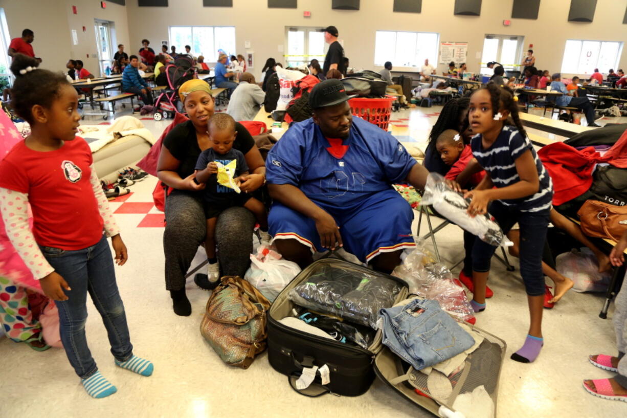 Family members, from left, Briana Jeunice, 7, Vernea Jones, 30, Greg Jones III, 18-motnhs Greg Jones Sr., 36, and Zahava Alexander, 7, settle into the Red Cross shelter at the Samuel S. Gaines Academy building in Fort Pierce Fla., Thursday Oct. 6, 2016, as Hurricane Matthew approaches Florida&#039;s east coast  (Douglas R.