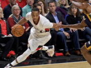 Portland Trail Blazers guard C.J. McCollum, left, dribbles past Utah Jazz guard Rodney Hood, right, during the first half of an NBA basketball game in Portland, Ore., Tuesday, Oct. 25, 2016.