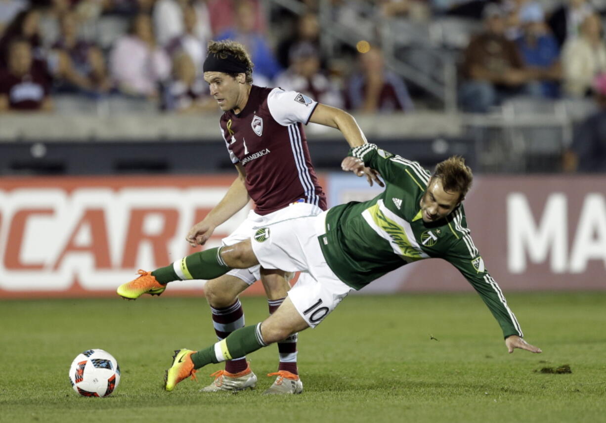 Colorado Rapids midfielder Dillon Powers pushes Portland Timbers midfielder Ned Grabavoy (10) down during the first half of an MLS soccer match Saturday, Oct. 1, 2016, in Commerce City, Colo.