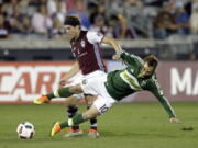 Colorado Rapids midfielder Dillon Powers pushes Portland Timbers midfielder Ned Grabavoy (10) down during the first half of an MLS soccer match Saturday, Oct. 1, 2016, in Commerce City, Colo.