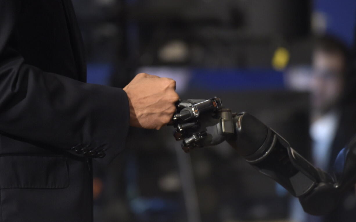 President Barack Obama does a fist bump with Nathan Copeland during a tour of innovation projects at the White House Frontiers Conference at University of Pittsburgh in Pittsburgh, Thursday, Oct. 13, 2016. Copeland demonstrates how he can control a robotic arm and feel when the robotic hand is touched.