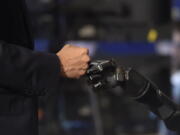 President Barack Obama does a fist bump with Nathan Copeland during a tour of innovation projects at the White House Frontiers Conference at University of Pittsburgh in Pittsburgh, Thursday, Oct. 13, 2016. Copeland demonstrates how he can control a robotic arm and feel when the robotic hand is touched.