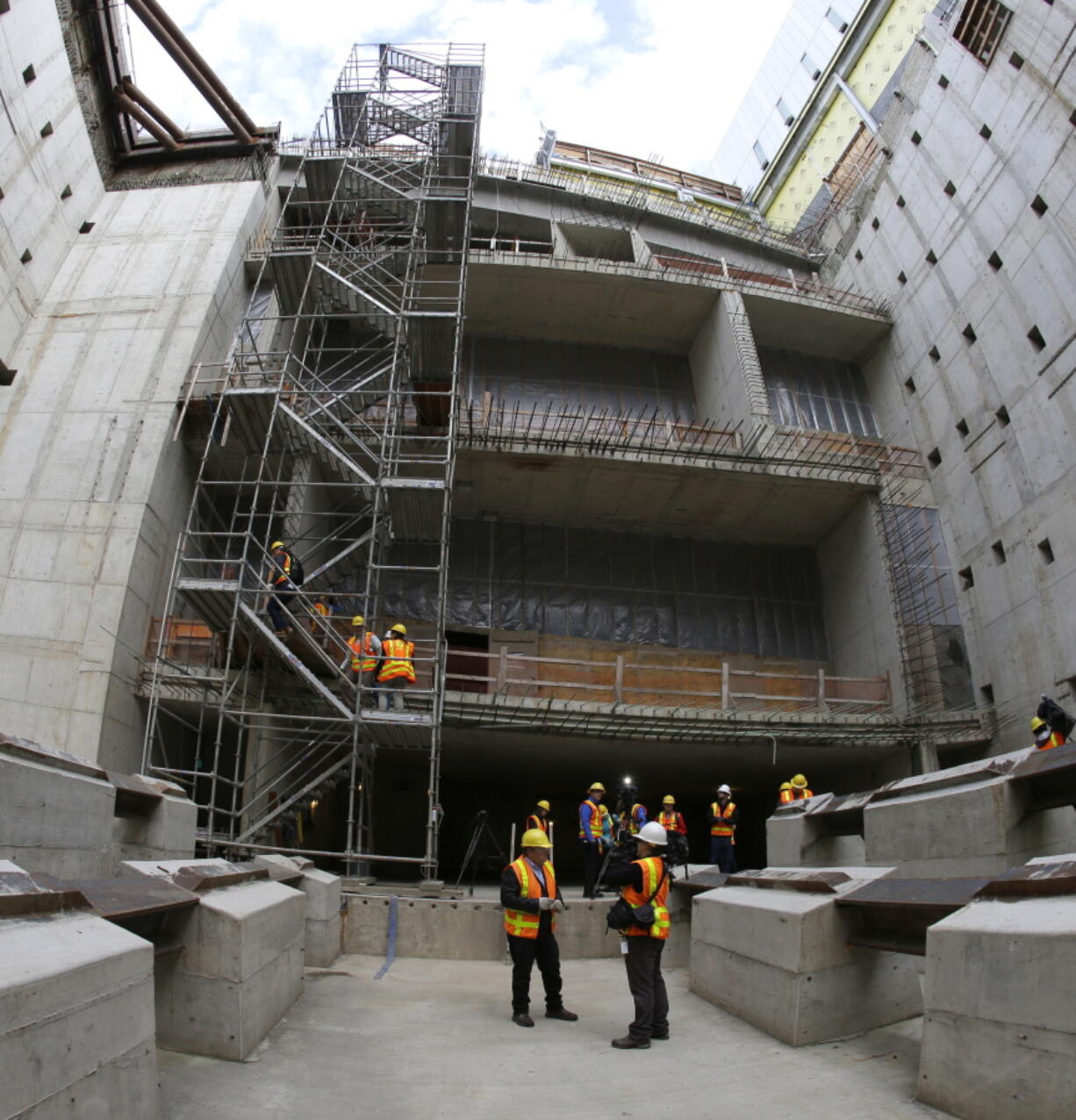 Visitors climb a scaffolding Monday next to what will be the double-decker north- and southbound lanes at the end of the nearly 2-mile tunnel of the Highway 99 project to replace the earthquake-damaged Alaskan Way Viaduct in Seattle. Officials said Monday that Bertha, the giant drilling machine, had passed the halfway mark as it digs beneath the city. (Ted S.