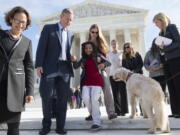 Ehlena Fry, 12, is helped down the steps of the Supreme Court in Washington on Monday by her mother, Stacy Fry, and Michael J. Steinberg, ACLU of Michigan Legal director, and dog Wonder, following oral arguments in Fry&#039;s case who has cerebral palsy who, at age 5, was banned from bringing her service dog, Wonder, to class.