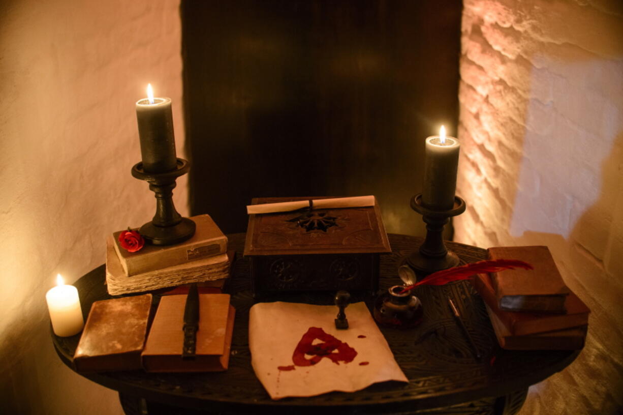 Candles and books are arranged on a table before a photo shoot of a room in Bran Castle, in Bran, Romania on Oct. 9, 2016.