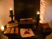 Candles and books are arranged on a table before a photo shoot of a room in Bran Castle, in Bran, Romania on Oct. 9, 2016.