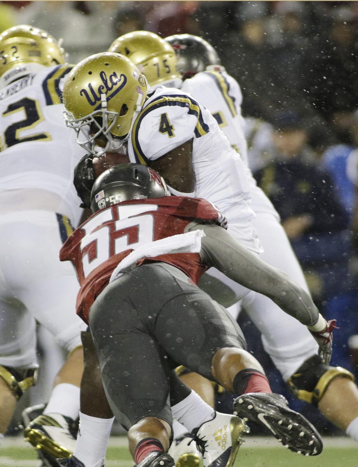 Washington State linebacker Derek Moore (55) brings down UCLA running back Bolu Olorunfunmi (4) during the first half of an NCAA college football game in Pullman, Wash., Saturday, Oct. 15, 2016.