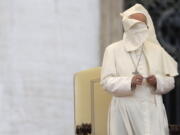 A gust of wind blows the mantle of Pope Francis as he leads a Marian vigil prayer in St. Peter&#039;s square at the Vatican on Saturday.