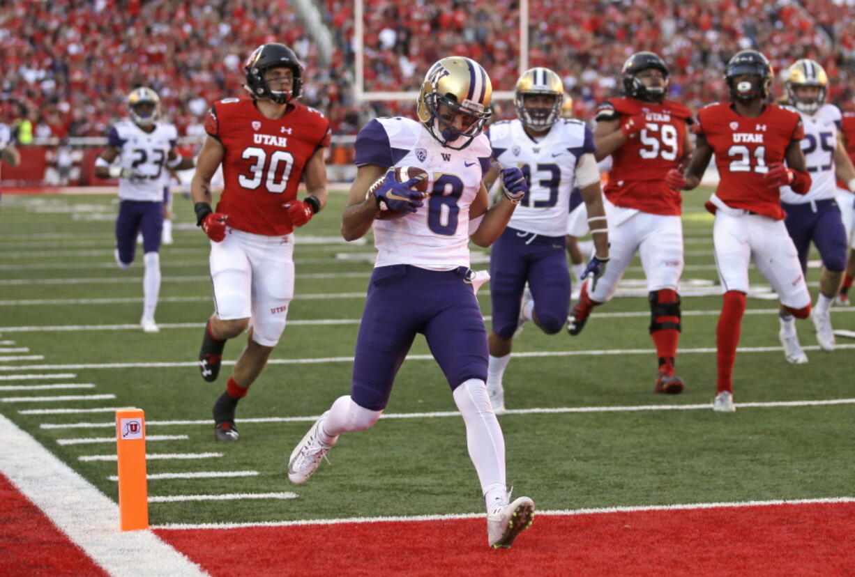 Washington punt returner Dante Pettis (8) scores a touchdown against Utah in the second half of an NCAA college football game, Saturday, Oct. 29, 2016, in Salt Lake City. Washington won 31-24.