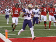 Washington punt returner Dante Pettis (8) scores a touchdown against Utah in the second half of an NCAA college football game, Saturday, Oct. 29, 2016, in Salt Lake City. Washington won 31-24.