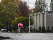 Wind overwhelms a pedestrian's umbrella as she crosses Main Street in downtown Vancouver on Friday morning.