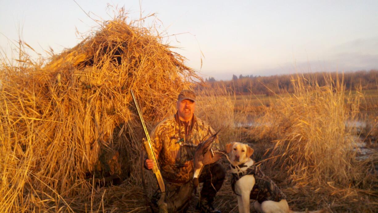 Doug Hargin of Vancouver, along with his yellow Labrador Riley, holds a pintail shot in the Shillapoo Wildlife Area of the Vancouver Lake lowlands.