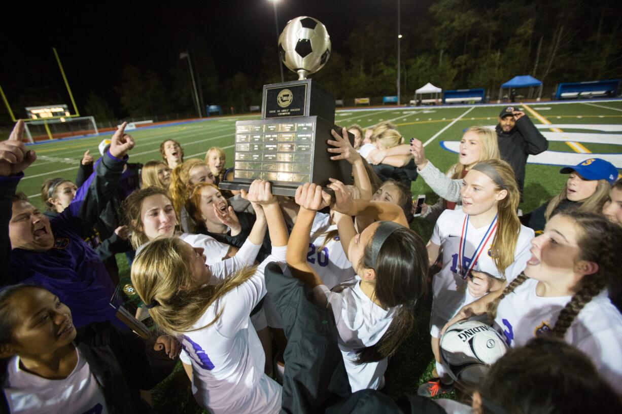 Columbia River players lift the Class 2A state championship trophy after they defeated Liberty in a shootout on Saturday, Nov. 19, 2016 at Shoreline Stadium in Shoreline, Wash.