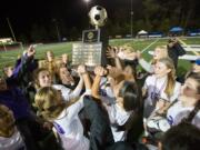 Columbia River players lift the Class 2A state championship trophy after they defeated Liberty in a shootout on Saturday, Nov. 19, 2016 at Shoreline Stadium in Shoreline, Wash.