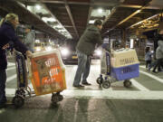 Melissa McClellan, left and Matt Niederberger of Posh Pets Rescue, Long Beach, N.Y., cart Max and Brandy, feral rescue dogs, to the car from arrivals at JFK International Airport in Queens, N.Y. Max and Brandy are two of five rescue dogs who arrived from Thailand and will be adopted by American families.