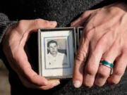 Vancouver resident Jeremiah Thompson holds a photo of his grandfather Dewey E. Clark when he was 22 years old. Thompson is running his first marathon, the Athens Marathon, today in honor of his grandfather, who ran 12 marathons before his death last year.