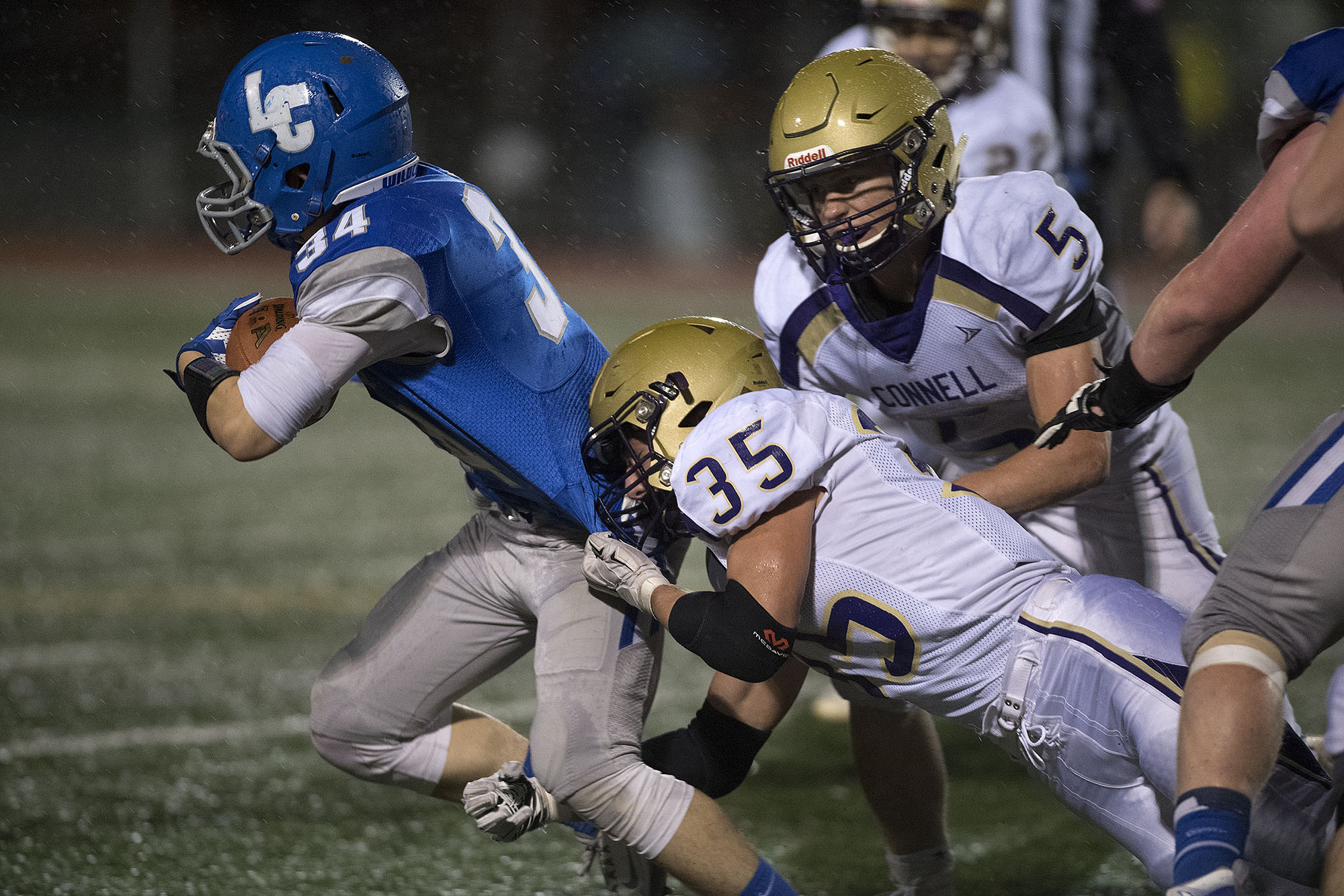 La Center's Blake Krout (34) tries to get past Connell's Tristen Garland (35) and Brian Hawkins (5) in the third quarter at McKenzie Stadium on Saturday night, Nov. 26, 2016.