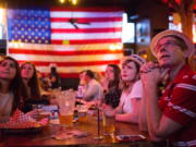 People watch returns trickle in during an election night watch party Tuesday at The Comet Tavern in Seattle.