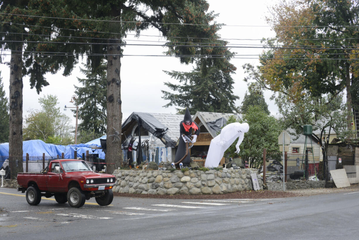 A vehicle waits to turn the corner at Northeast 112th and Northeast Rosewood avenues near Covington Middle School on Oct. 18. Code enforcement has cited the property owner for, among other things, junk piled up along the road, making it difficult for drivers to see and safely turn.