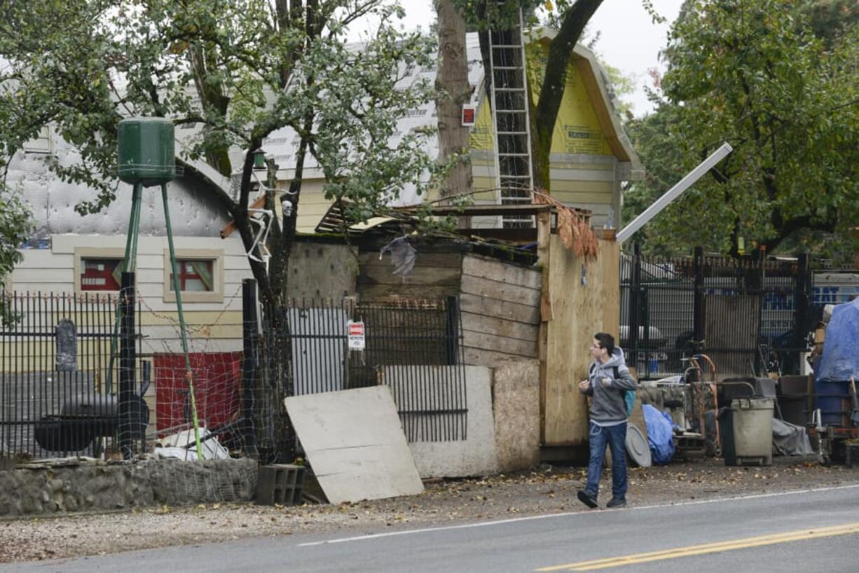 A Covington Middle School student walks past a property that has been on the radar of Clark County Code Enforcement for two years and is located across the street from the school. Since police activity at the home earlier this year, the county has received more complaints from parents.