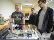 From left to right, students David Gullickson, Toby Sabandith and Bruce Gates, test a pick-and-place robot during their mechatronics class at Clark College in Vancouver on Wednesday. Clark College is tailoring its advanced manufacturing programs to better meet the needs of local companies.