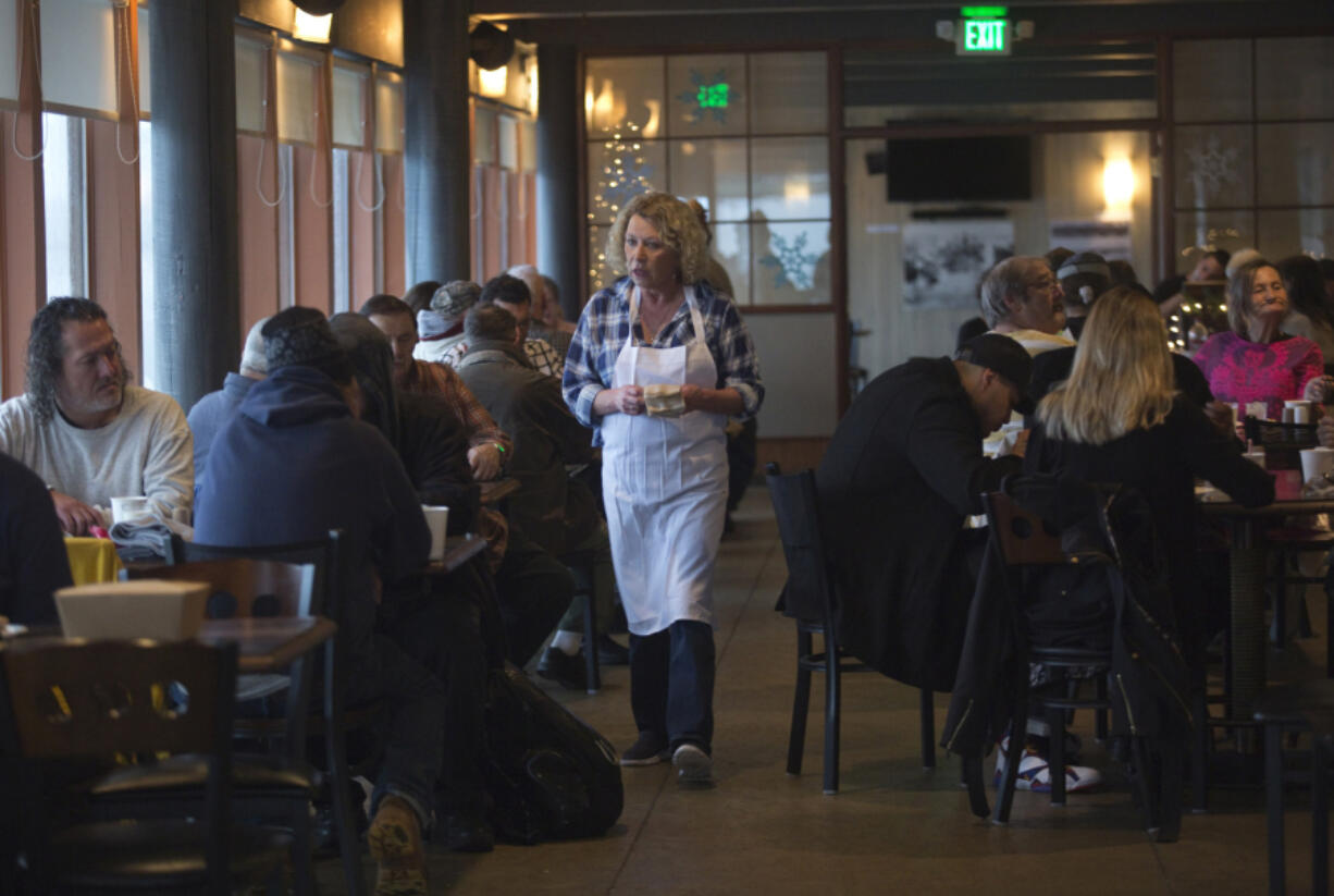 Volunteer Mickey Thompson Giese helps patrons as she serves free Thanksgiving meals in Vancouver in 2016.