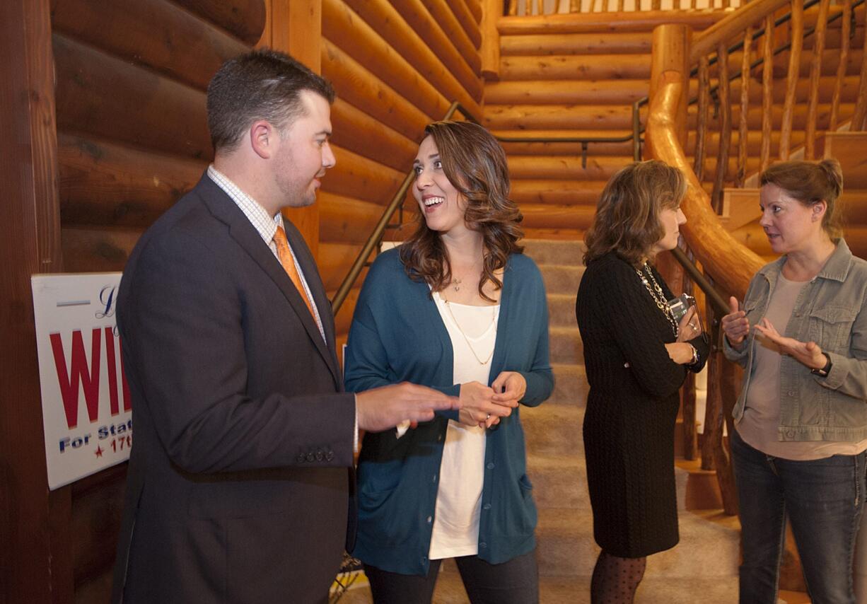 Candidates Brandon Vick, from left, Jaime Herrera Beutler, Lynda Wilson and Ann Rivers chat after taking a group photo at Summit Grove Lodge in Ridgefield on Tuesday night.