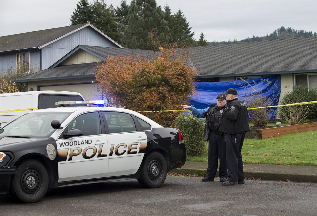 Officer Jim Keller, left, talks with Officer Rudy Podhora at the scene of a possible homicide in Woodland on Tuesday morning.