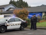 Officer Jim Keller, left, talks with Officer Rudy Podhora at the scene of a possible homicide in Woodland on Tuesday morning.