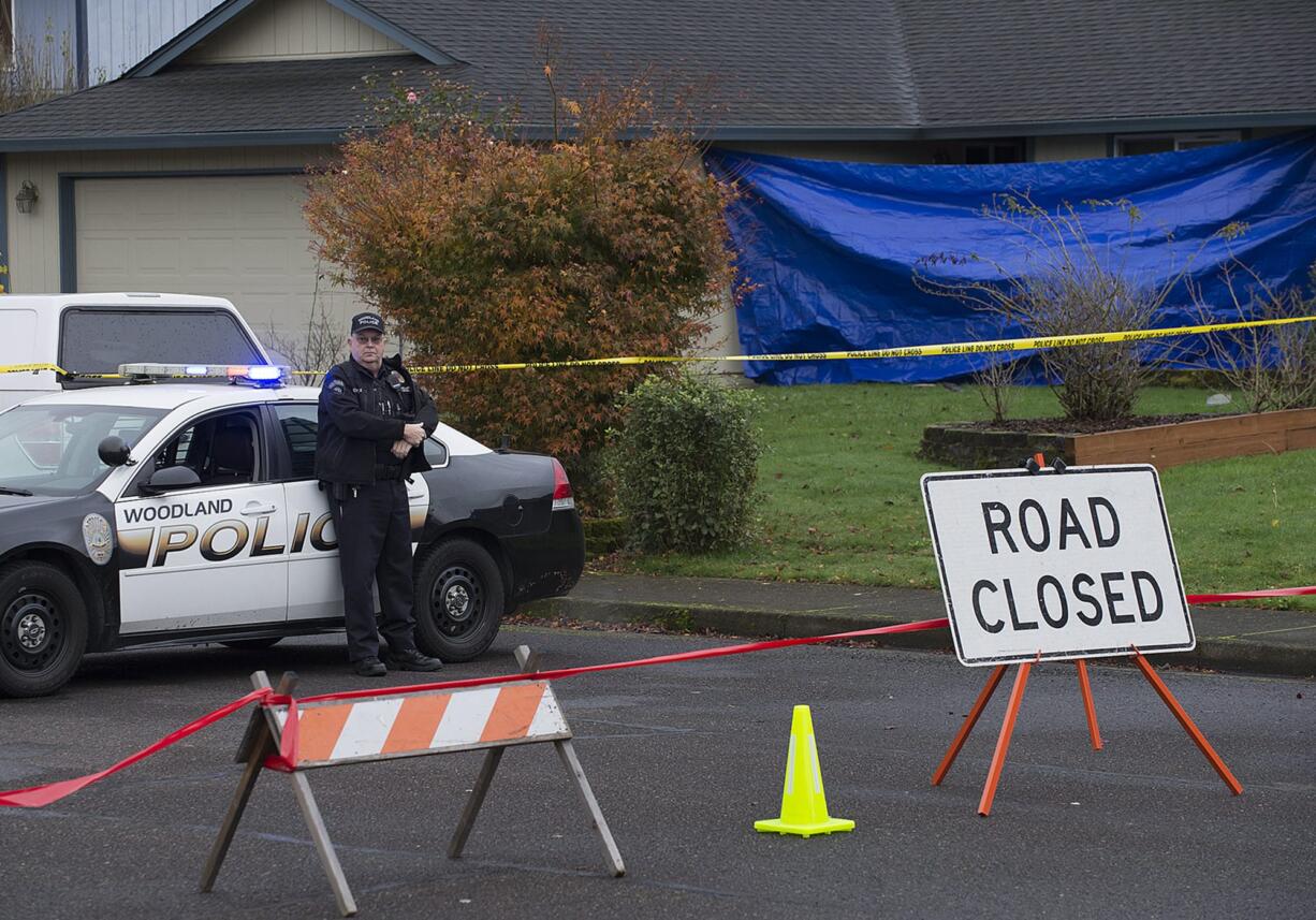 Officer Rudy Podhora keeps watch at the scene of a possible homicide in Woodland on Tuesday morning.