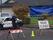 Officer Rudy Podhora keeps watch at the scene of a possible homicide in Woodland on Tuesday morning.