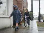 Mary Siebert, left, delivers mail to the Clark County Veterans Assistance Center in Vancouver in the rain on Oct. 13.