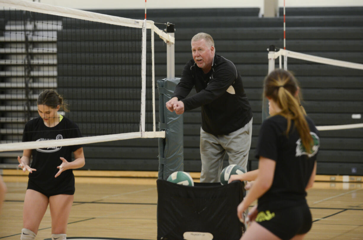 Coach Jeff Nesbitt demonstrates proper posture to Woodland volleyball players during practice at Woodland High School, Wednesday November 9, 2016.