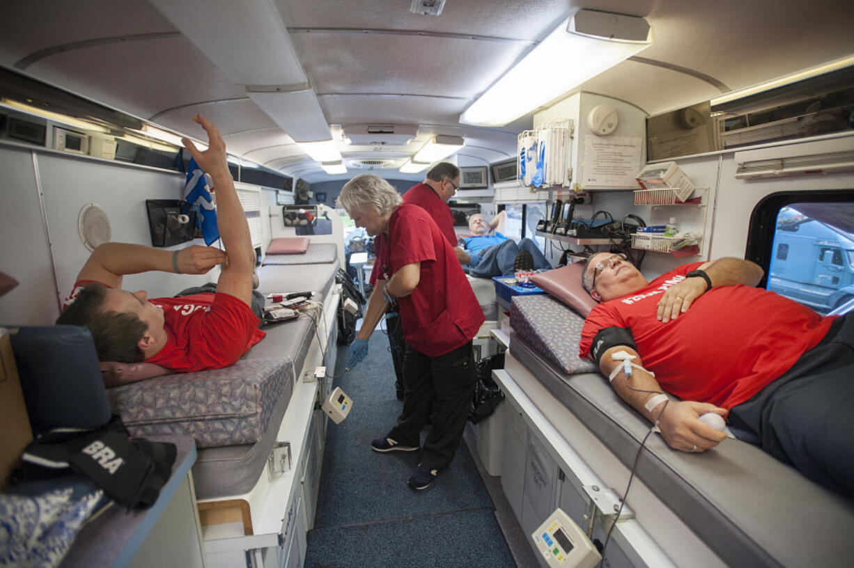 Jason Hutchinson, left, and Mitch Taylor, right, donate blood Wednesday in honor of Lyn Hutchinson -- Jason Hutchinson&#039;s father and Taylor&#039;s colleague -- who was diagnosed with a glioblastoma brain tumor in August and given three to five months to live. Lyn Hutchinson had donated 19 gallons of blood to the American Red Cross before his health took a turn, so his colleagues at Columbia Ultimate in Vancouver held a blood drive to help Hutchinson reach his 20-gallon donation goal.