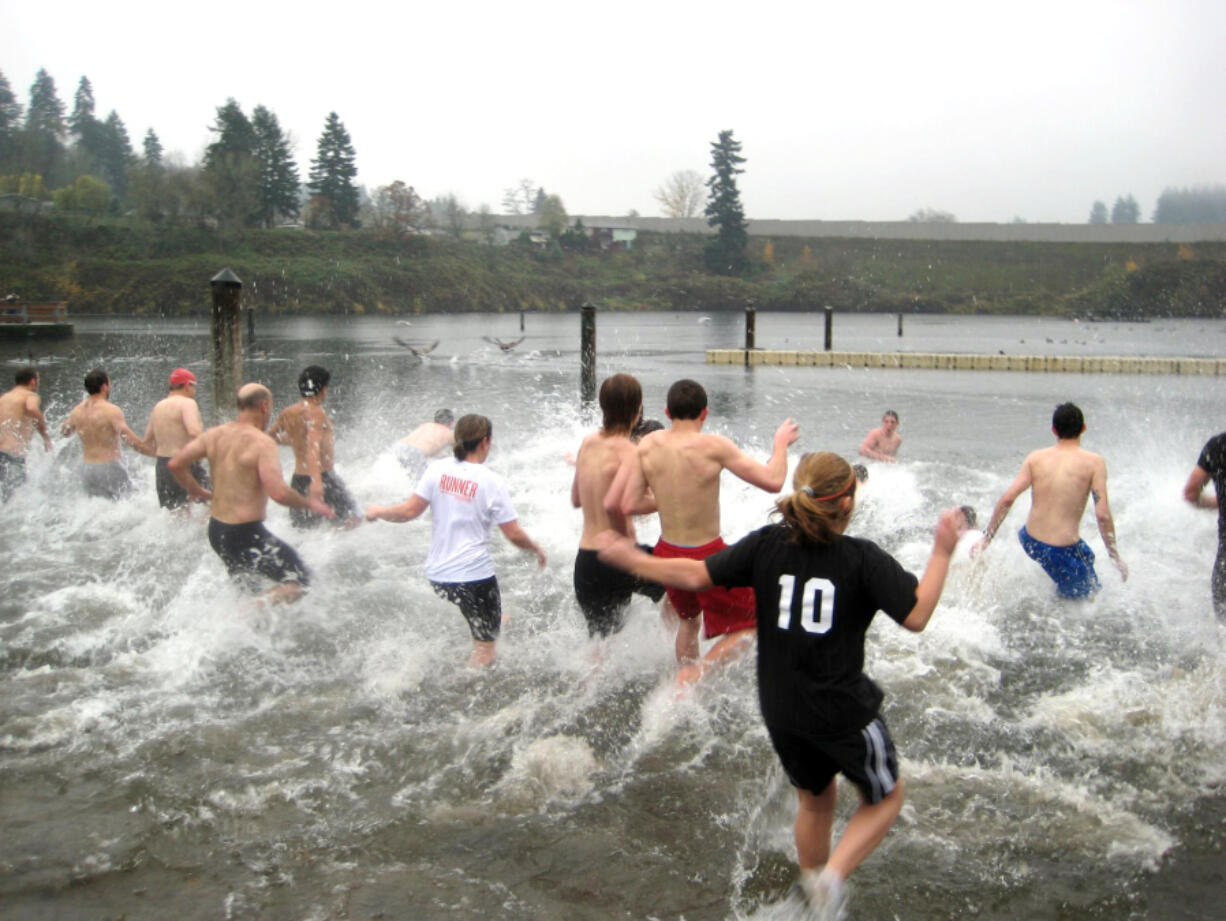 People brave the cold water of Klineline Pond for a polar bear swim during the Turkey Trot.