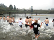 People brave the cold water of Klineline Pond for a polar bear swim during the Turkey Trot.