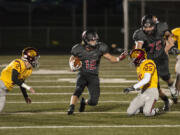 Camas&#039; running back Michael Matthews (12) escapes Enumclaw&#039;s defense during the first quarter. He rushed for 35 yards and one touchdown.