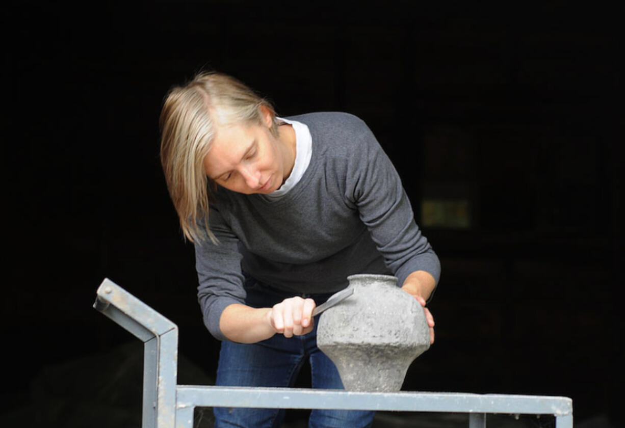 Claire Bandfield working on a hand-cast stone pot at her studio in Camas.