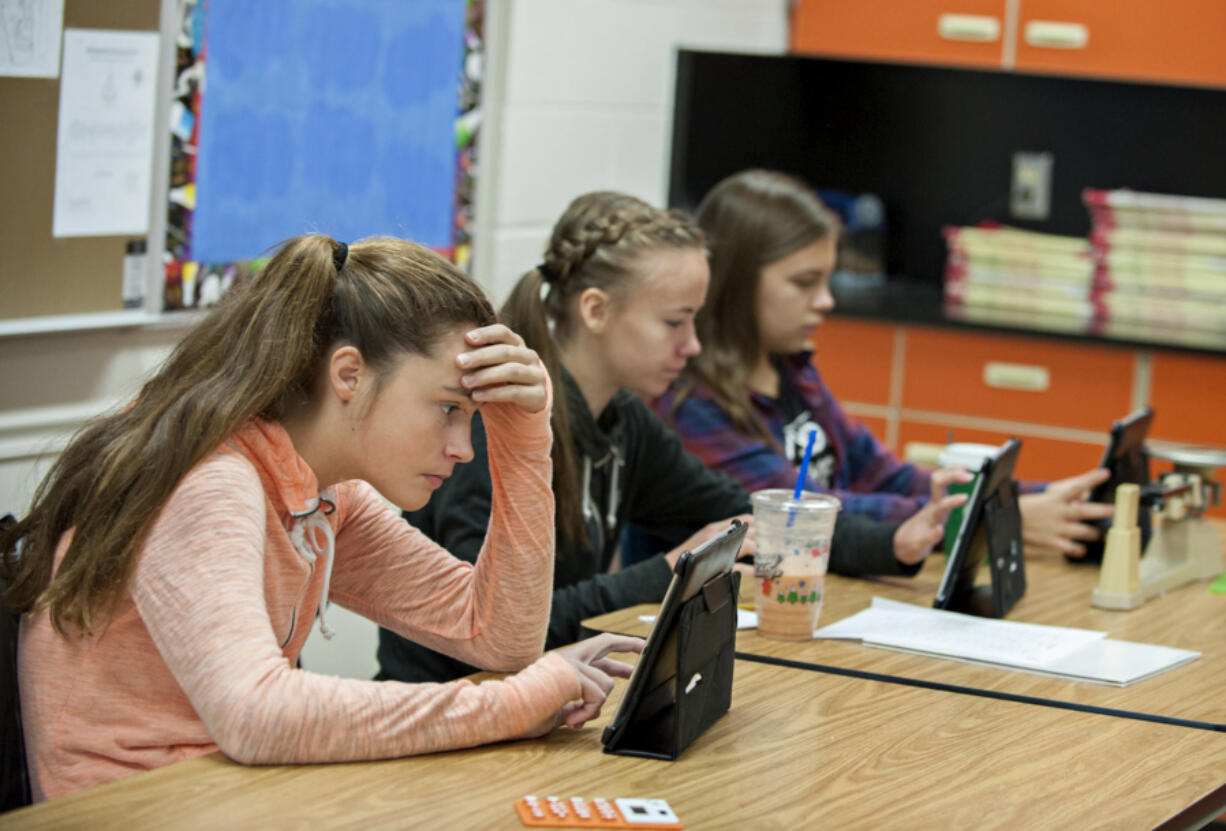 Eighth-graders Malia Erickson, from left, Reese Hendershaw, and Maddi Kangas, all 13, cast their votes during the Kids Vote 2016 mock election at Hockinson Middle School on Friday morning. The online ballots are available through 8 p.m. Tuesday.