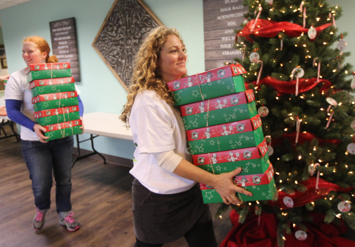 Operation Christmas Child volunteer Bobbi Mauna, right, manages donations Sunday at Felida Bible Church. The program sends shoeboxes full of toys, toiletries and other items to children living in poverty overseas.