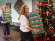 Operation Christmas Child volunteer Bobbi Mauna, right, manages donations Sunday at Felida Bible Church. The program sends shoeboxes full of toys, toiletries and other items to children living in poverty overseas.