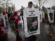 A Boy Scout marching with the Gold Star families on Saturday carries a banner honoring U.S. Army Sgt. Elijah Rao, who was killed in 2009 by a roadside bomb in Afghanistan, during Vancouver&#039;s 30th annual Lough Legacy Veterans Parade at Fort Vancouver.