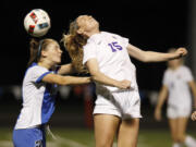 Columbia River's Katie Anthony (15) heads the ball as Olympic's Sydney Troy (left) closes in during girls soccer state tournament first-round game at Kiggins Bowl.