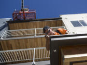 Construction worker George Somarakis installs drip metal at Isabella Court in September. A grand opening for the affordable-housing complex for seniors is planned for February.